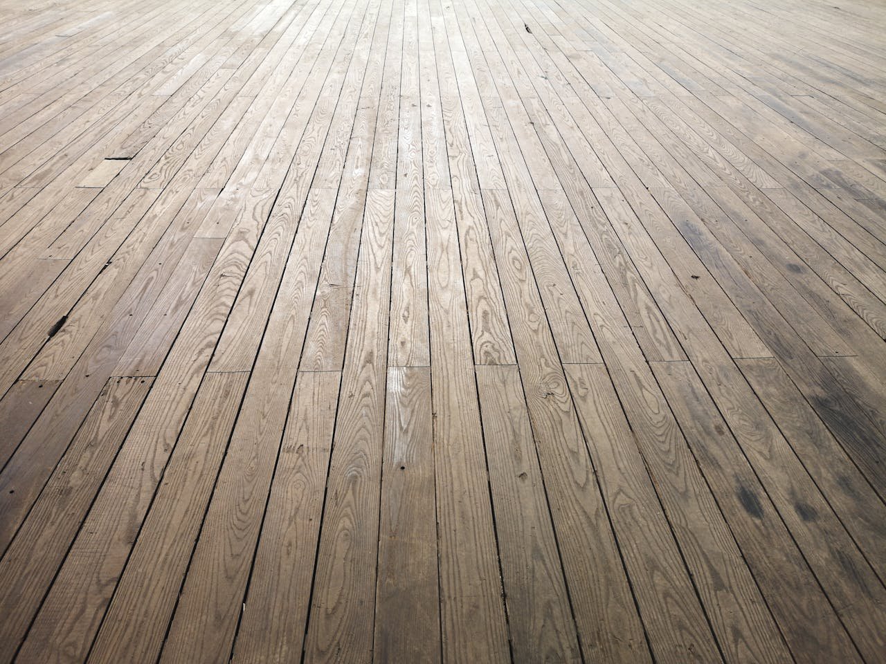 A wide angle view of aged wooden floor planks showing natural texture and grain pattern.